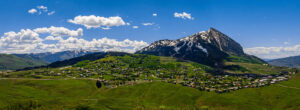 Panoramic photo of Crested Butte Colorado with mountains in the background.